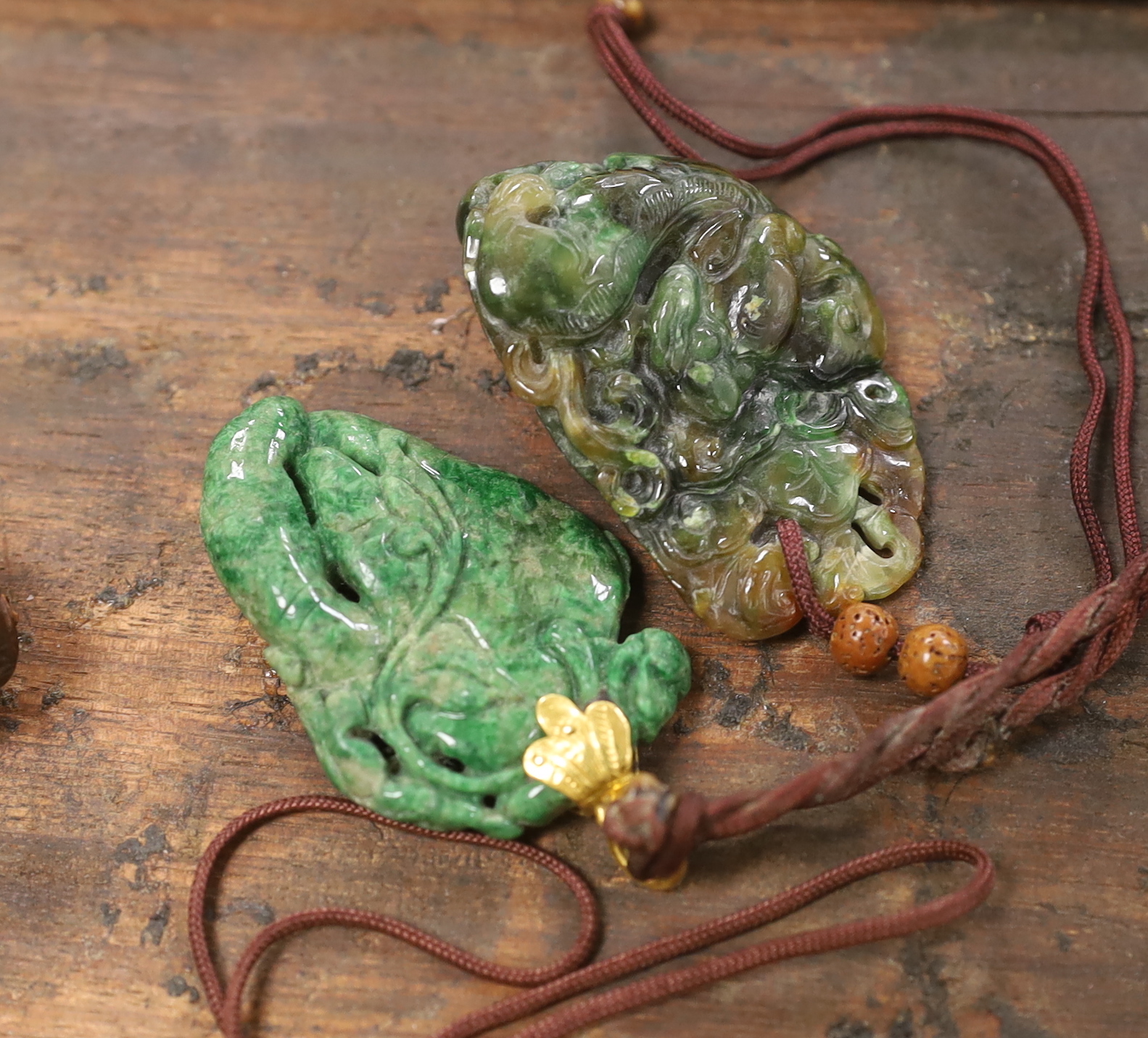 Five Chinese jadeite pendants and two wood lion-dog netsuke, netsuke 3.5 high